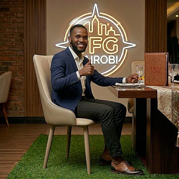Professional man in a navy blazer giving a thumbs up while seated on a premium cream JNRD10-1 leather dining chair in Lavington, Nairobi.
