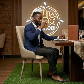 Professional man in a navy blazer enjoying juice while seated on a cream JNRD10-1 leather dining chair in a luxury Lavington dining room, Nairobi.