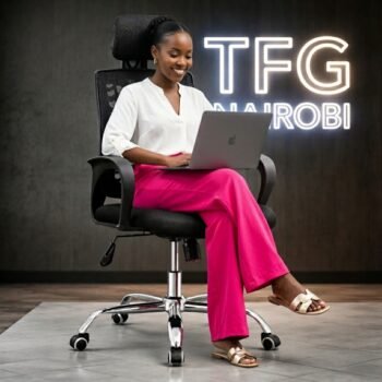 A professional structural engineer in a white blouse and pink trousers working on a laptop while sitting comfortably on an FS5003 high-back ergonomic mesh office chair with a headrest in a Parklands Nairobi office.