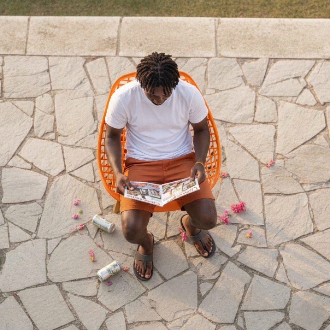 Pangani Modern Seating – TFG Nairobi Top-down view of a man sitting on an orange EO197O Eames chair in a Pangani residence.