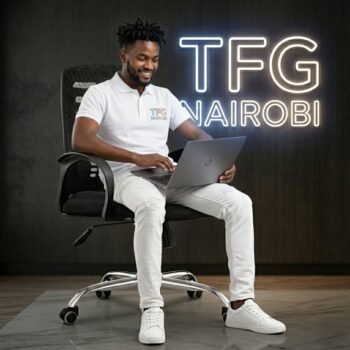 A professional graphic designer using a laptop while sitting on the FS948 mid-back ergonomic mesh office chair with a chrome swivel base in a Westlands Nairobi studio.