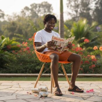 Young man sitting on a comfortable orange EO197O Eames chair in a Kileleshwa home.