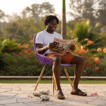 Man reading a magazine on a comfortable EO197P purple Eames molded chair in Gigiri.
