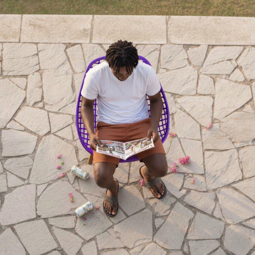 Muthaiga Executive Lifestyle – EO197P Top-down view of a man reading a lifestyle magazine on a purple EO197P Eames chair in Muthaiga.