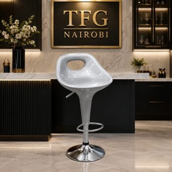 PMBS900-1 grey bar stool with a chrome pedestal base staged in front of a luxury black and marble kitchen island with the TFG Nairobi logo.