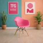 EO1571PK Eames armchair with wooden legs and molded plastic shell for luxury coastal interiors in Mombasa Kenya.