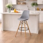 Gray EO1801 Eames bar chair with padded PU leather seat and chrome braces in a modern Lavington kitchen.