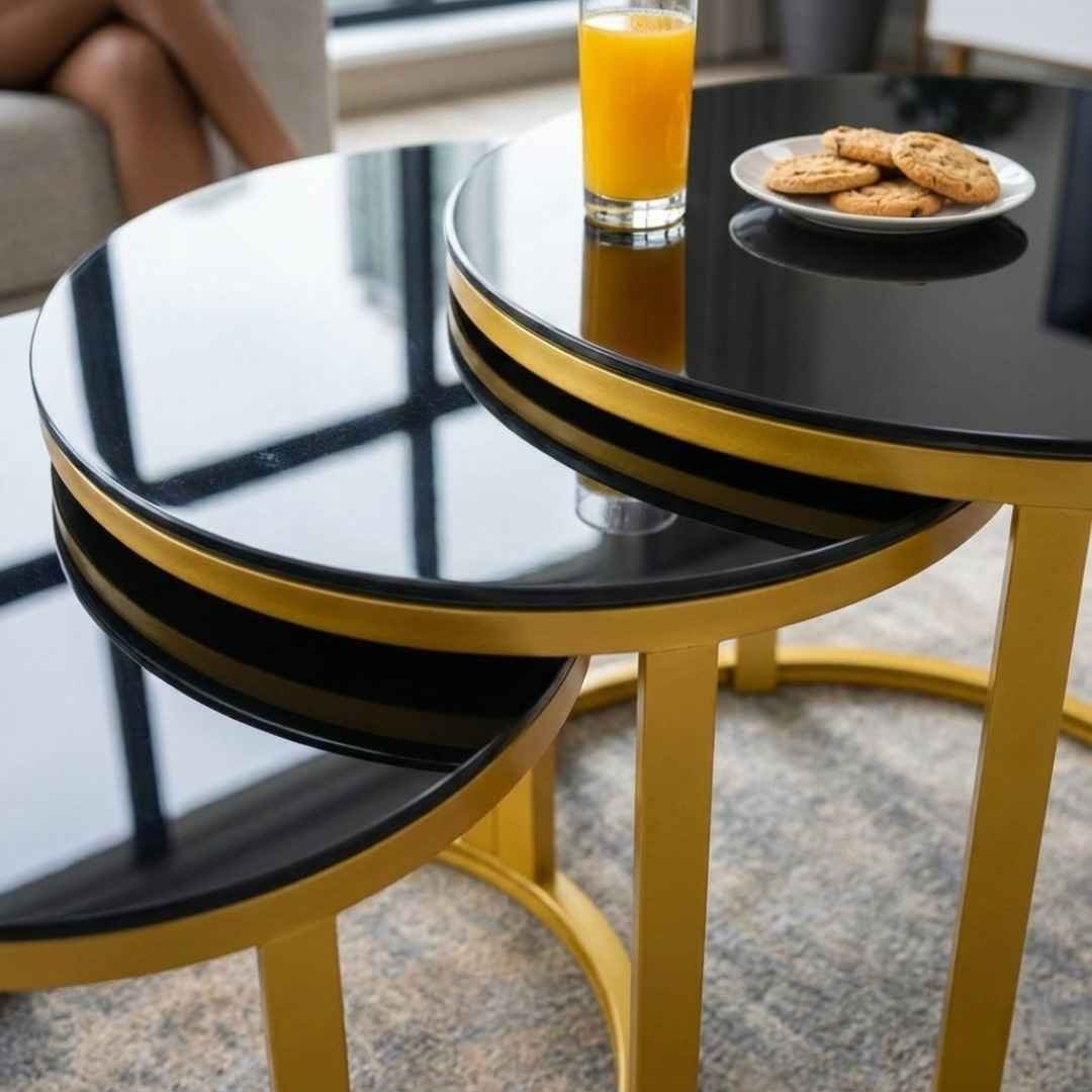 1+80 Nesting Table Material Detail - TFG Nairobi Close-up detail of the smooth black tempered glass and gold metal frame of the 1+80 nesting table