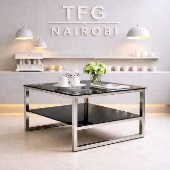 Modern LUXC1800-1 black glass coffee table with reflective chrome frame and lower storage shelf in a luxury Westlands apartment setting.