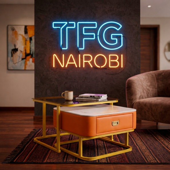 Luxury PF-LUX1200 Nesting Tables set with a glass top, gold frame, and orange leather storage drawer in a Kilimani living room.