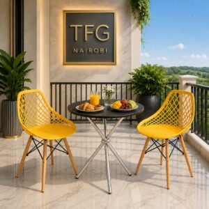 The ECBT3-2 Yellow Balcony Set — The Ultimate Outdoor Bistro Set in Nairobi featuring two bold yellow lattice-back chairs and a round black glass-top table styled with croissants, tropical fruit, orange juice and white flowers on a luxury marble balcony in Karen, Nairobi, Kenya