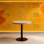 Round pedestal table with grid-pattern top and wood edge trim at a home in Runda, Nairobi